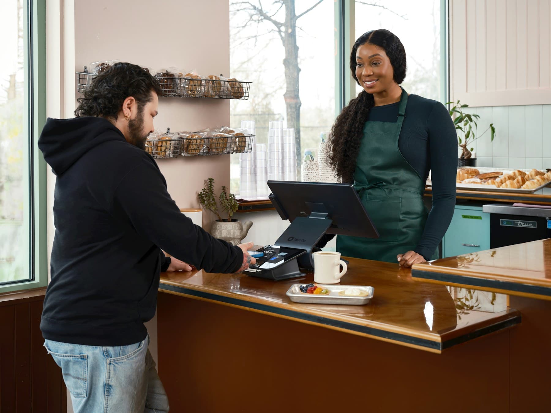 Customer paying by phone at a cafe counter